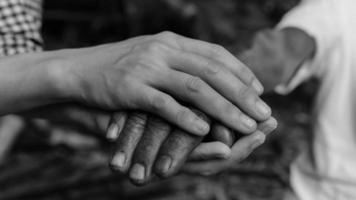 mains du vieil homme et une main d'homme noir et blanc photo