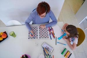 mère et petite fille jouant ensemble dessinant des illustrations créatives photo
