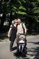 couple avec bébé landau dans le parc d'été photo