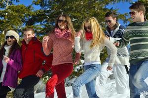 les amis s'amusent en hiver sur la neige fraîche photo