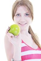 heureuse jeune femme mange une pomme verte isolée sur blanc photo