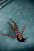 jolie jeune femme se relaxant dans la piscine photo