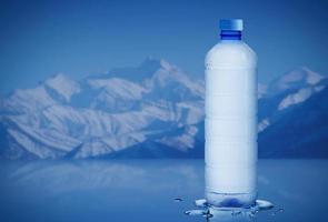 bouteille d'eau minérale pure avec des gouttes d'eau dans le fond de l'iceberg, concept d'hydratation de soins de santé et de beauté photo