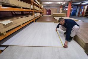 charpentier mesurant une planche de bois photo