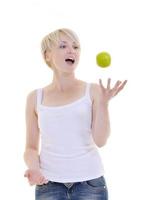 heureuse jeune femme mange une pomme verte isolée sur blanc photo