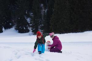 famille heureuse construisant un bonhomme de neige photo