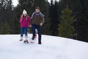 couple s'amusant et marchant en raquettes photo