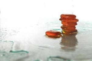 pierres zen humides isolées avec des éclaboussures de gouttes d'eau photo