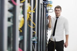 jeune ingénieur informatique dans la salle des serveurs du centre de données photo