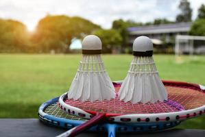 raquette de badminton et volant de badminton sur fond nuageux et ciel bleu, concept de jeu de badminton en plein air. mise au point sélective sur la raquette. photo