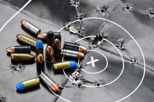 Balles de pistolet de 9 mm et obus de balle sur papier cible de tir, mise au point douce et sélective. photo