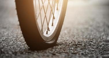 roue plate arrière en gros plan d'un vélo vintage sur la chaussée le soir de la journée, lumière du coucher du soleil éditée, mise au point douce et sélective photo