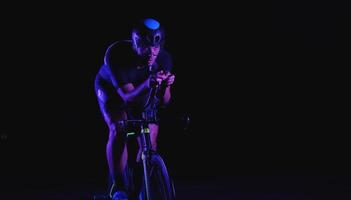 athlète de triathlon faisant du vélo rapidement la nuit photo