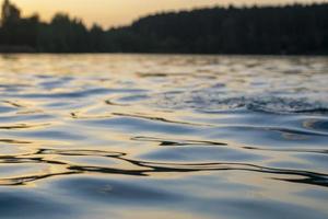 coucher de soleil atmosphérique derrière les arbres et reflet dans l'eau. photo