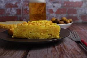 vue de dessus de l'omelette de pommes de terre espagnole typique avec du pain, des couverts et une chope de bière