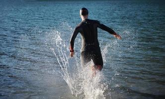 athlète de triathlon commençant l'entraînement de natation sur le lac photo