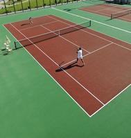 heureux jeune couple jouer au tennis en plein air photo