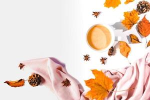concept d'automne ou d'hiver avec des feuilles de pin et d'érable, une tasse de café, de la cannelle et une écharpe, plat, vue de dessus. photo