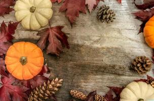 décor d'automne festif de citrouilles, de pins et de feuilles sur un fond en bois. concept de jour d'action de grâces ou d'halloween. composition d'automne à plat avec espace de copie. photo
