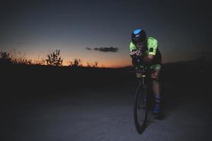 athlète de triathlon faisant du vélo rapidement la nuit photo