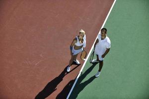 heureux jeune couple jouer au tennis en plein air photo