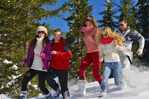 les amis s'amusent en hiver sur la neige fraîche photo