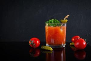 cocktail d'alcool Bloody Mary sur fond sombre. cocktail classique avec jus de tomate et vodka photo