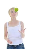 heureuse jeune femme mange une pomme verte isolée sur blanc photo