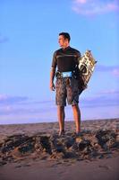 portrait d'un jeune homme kitsurf à la plage au coucher du soleil photo