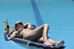 femme se détendre sur la piscine photo