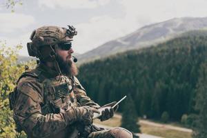 notion de guerre. soldat barbu en uniforme des forces spéciales dans une action militaire dangereuse dans une zone ennemie dangereuse étudie les tactiques d'attaque. mise au point sélective photo