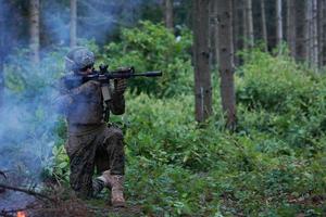 Soldat en action visant l'optique de visée laser de l'arme photo