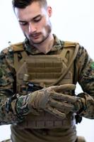 gros plan sur les mains d'un soldat mettant des gants de combat protecteurs photo