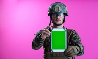 soldat montrant une tablette avec un écran vert vierge photo