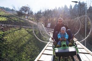 père et fils aime conduire sur les montagnes russes alpines photo