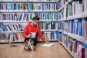 les élèves utilisent un cahier, un ordinateur portable et une bibliothèque scolaire photo