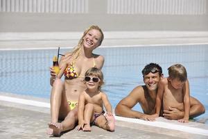 une jeune famille heureuse s'amuse à la piscine photo