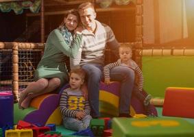 jeunes parents et enfants s'amusant dans la salle de jeux pour enfants photo