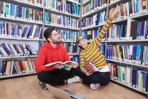 les élèves utilisent un cahier, un ordinateur portable et une bibliothèque scolaire photo