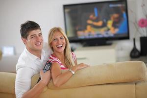 jeune couple détendu devant la télé à la maison photo