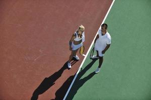 heureux jeune couple jouer au tennis en plein air photo