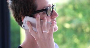 femme élégante utilisant un téléphone portable par fenêtre dans un immeuble de bureaux photo