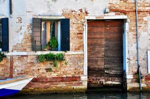 vieille porte et fenêtre en bois dans de vieux bâtiments à venise, italie. photo