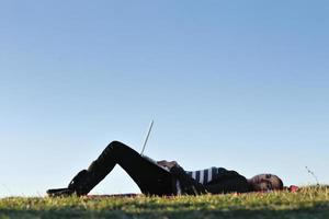 jeune adolescente travaille sur un ordinateur portable en plein air photo