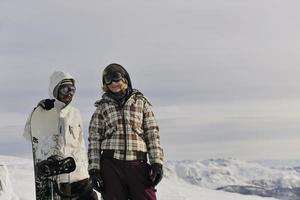 couple de snowboarders au sommet de la montagne photo