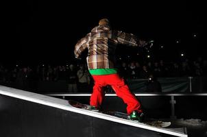 snowboarder freestyle sauter dans l'air la nuit photo