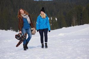 des amies dans une belle journée d'hiver ont une promenade détendue sur la neige photo