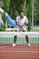 jeune homme jouer au tennis en plein air photo