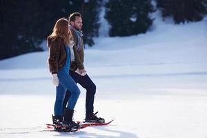 couple s'amusant et marchant en raquettes photo