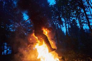 soldat en action la nuit sautant par-dessus le feu photo